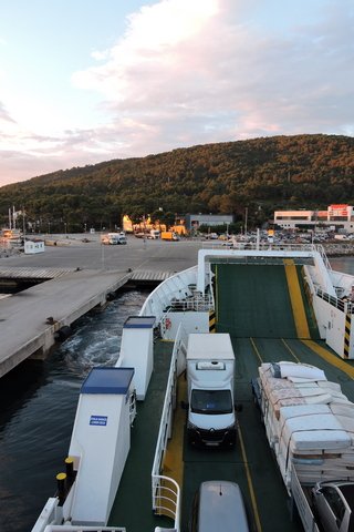 The ferry pulls away from the quay, as the sun illuminates the Trajekt