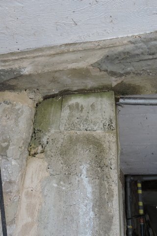 Damp seeping round the concrete support pillar